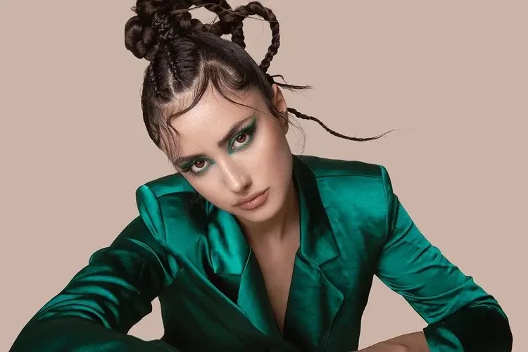 Model in emerald satin suit with braided updo